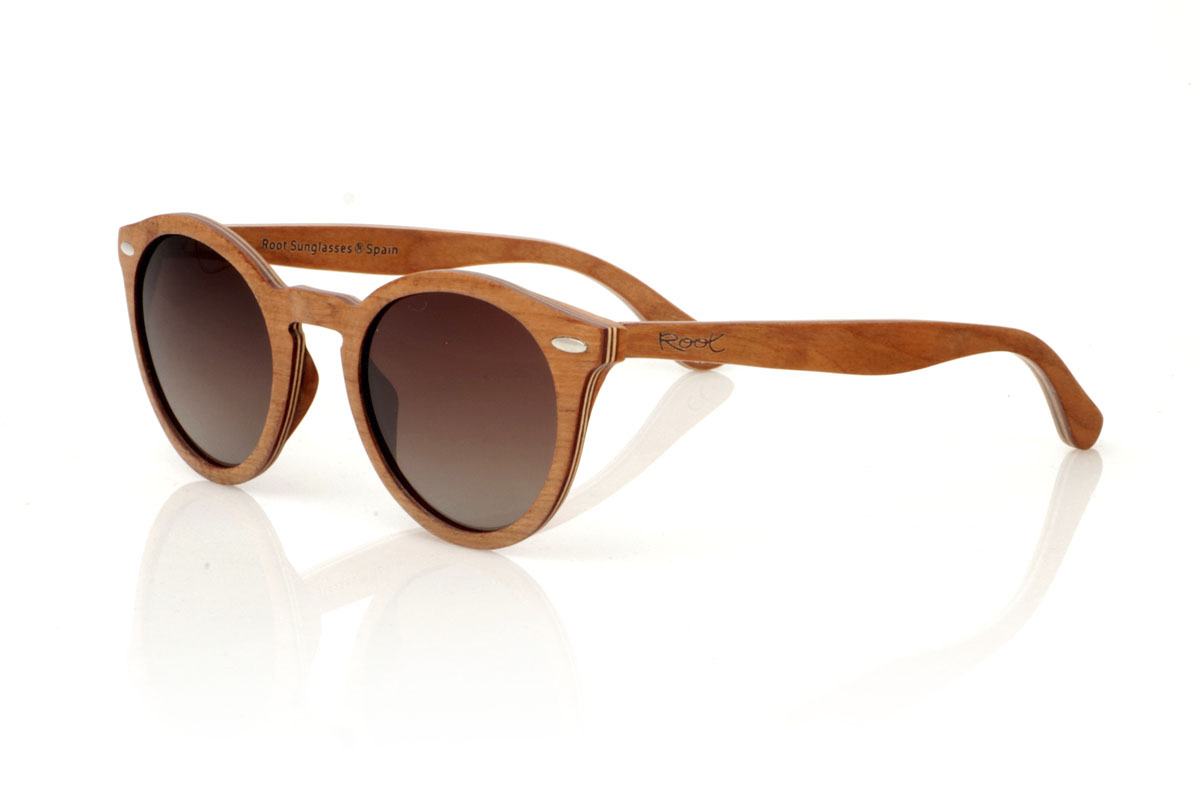 Wood eyewear of Cherry modelo LINDA. The LINDA wooden sunglasses come with a rounded and elegant silhouette, standing out for their cross-laminated cherry wood frame, which not only guarantees durability but also a unique style thanks to its beautiful grain. Silver metal pins on the front add a touch of class, balancing the warmth of the wood with a subtle shine. With tighter measurements of 140x49 and a caliber of 48, these glasses offer a comfortable fit and versatile style, perfect for those looking for a sophisticated and timeless accessory. | Root Sunglasses® 